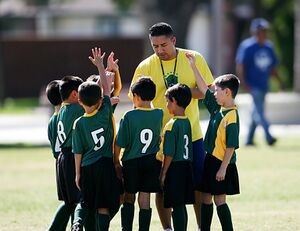 Picture of an AYSO Coach with players